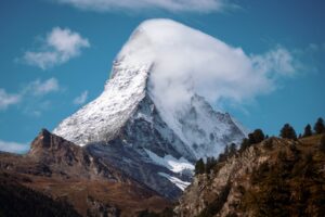 A steep snow-covered mountain peak rising into cloud.