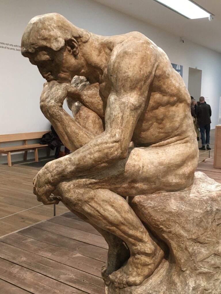 Men and Emotions: Why It’s So Hard to Talk Alex Golding Therapy Rodin's sculpture The Thinker, a seated figure resting his chin on his hand.