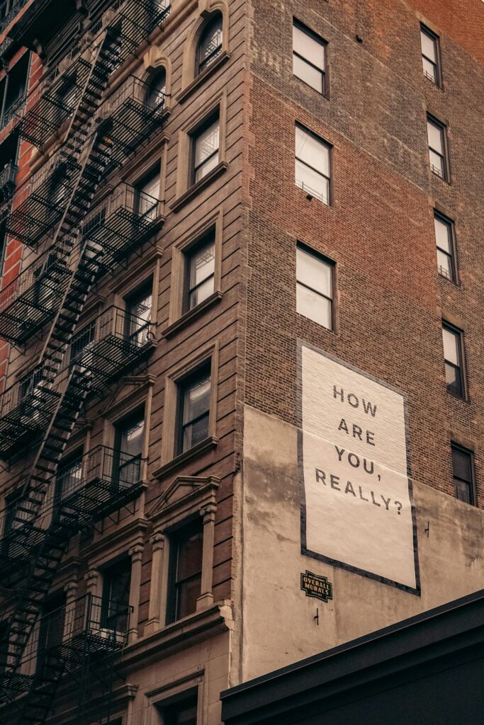 A tall brick building with a small sign beside its entrance.