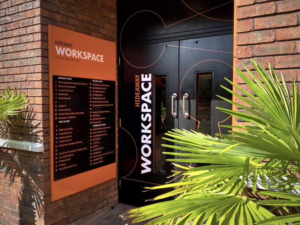 Hideaway Work Space Entrance to Alex Golding Therapy - plants, large door, and orange signage