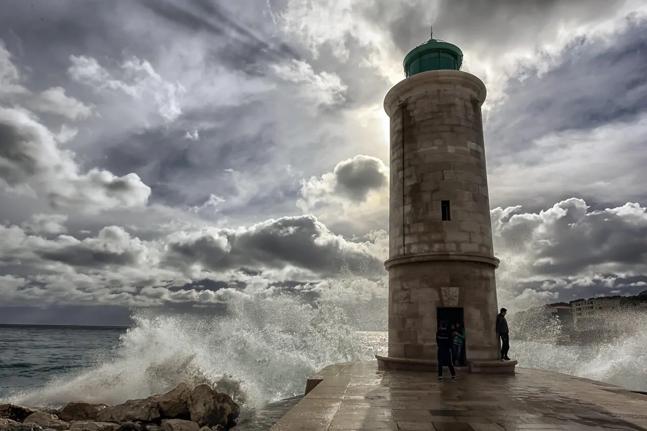 Men and Emotions: Why It’s So Hard to Talk Alex Golding Therapy A stone lighthouse on a headland beneath a wide bank of dark cloud.