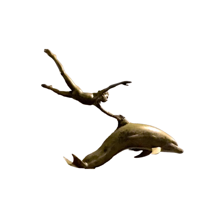 A bronze sculpture of a boy reaching up from the fin of a leaping dolphin.