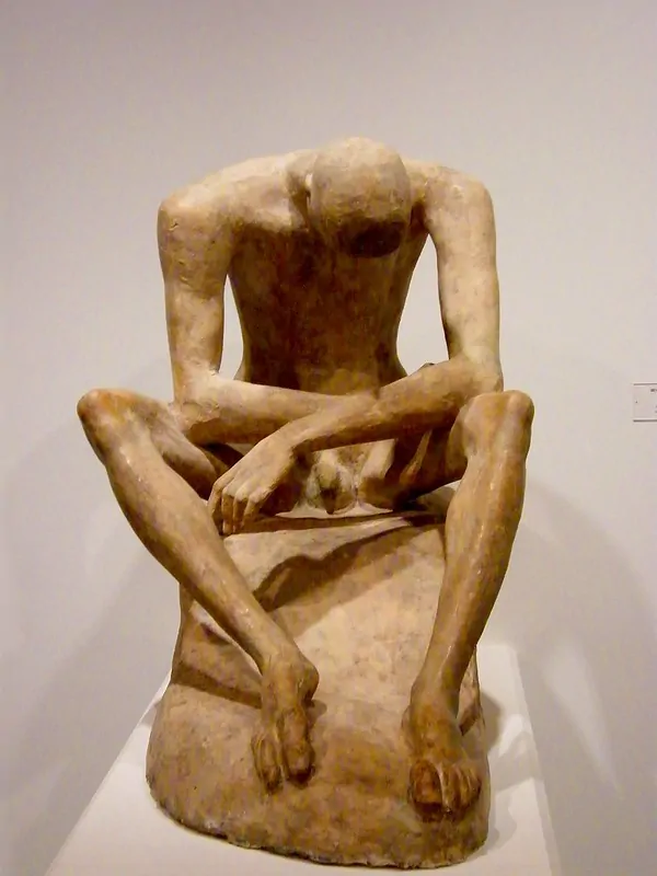 Depression therapy in London - Alex Golding Therapy A seated figure with both arms folded above the head.