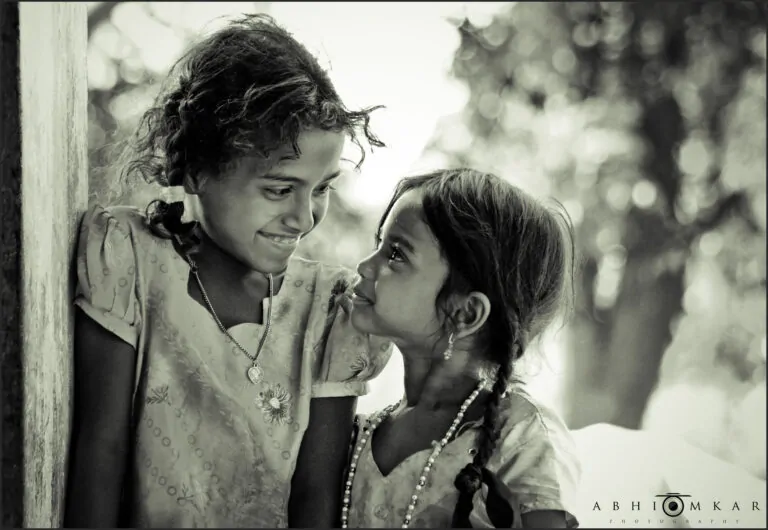 Conscious Kindness: A Compassionate Response to the Harsh Inner Critic Alex Golding Therapy Black and white photograph of two people close together, one speaking quietly into the other's ear.