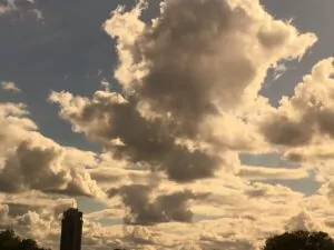 A wide sky of tall sunlit clouds seen from Hyde Park, London