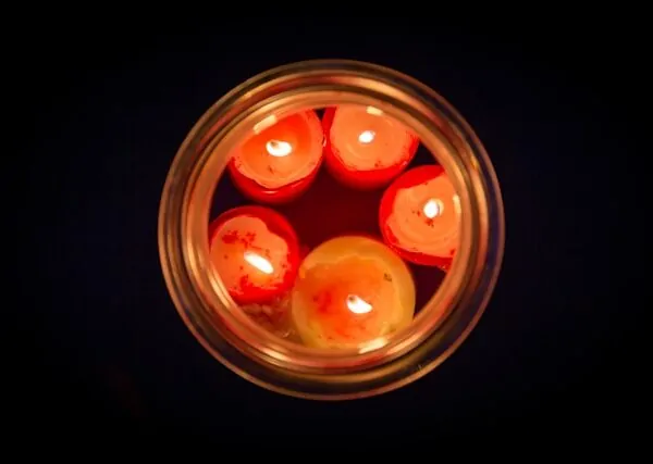 Buddhist Therapy London: Mindfulness Counselling & the Spiritual Approach Alex Golding Therapy Small red candles floating in a bowl of water, lit in a dark room.